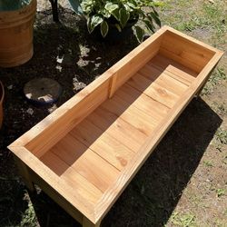  A container made of cedar wood designed for planting flowers & More.