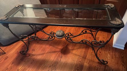 This is a wrought iron and wood console (sofa) table with a glass inset top
