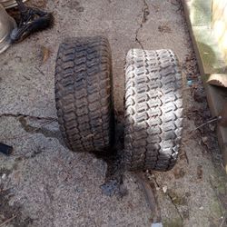 2 riding lawn mower tires with rims.