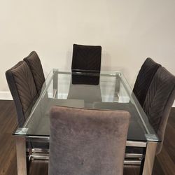 Beautiful modern glass dining table set with 6 upholstered chairs in excellent condition.