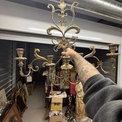 Ornate gilt metal three-arm wall sconce with scrolling leaf motifs.