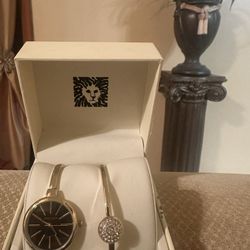 Anne Klein Women's Gold-Tone Bangle Watch and Bracelet Set with a black dial.