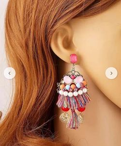 Unique vintage earrings with a mix of colors, featuring a mix of materials like metal, glass, and fabric. 