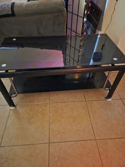 2 Tier Tempered Glass, Black in color Media Stand. 44x24. Very Sturdy, metal legs, no damage. Must Pick Up In Horizon.