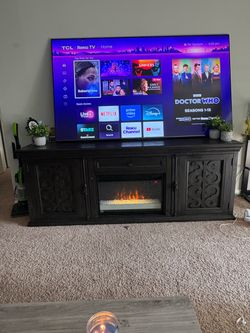 Heavy-duty wood entertainment center with built-in electric fireplace.