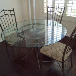 Wrought iron round glass table with 4 matching chairs  48 inch round