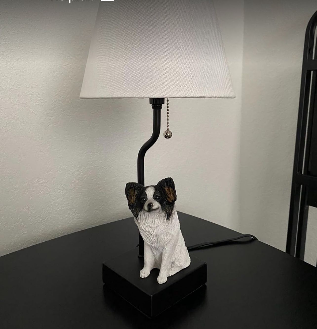 Illuminate your space with this charming table lamp featuring a delightful dog design. The white shade complements the playful figure, adding a touch