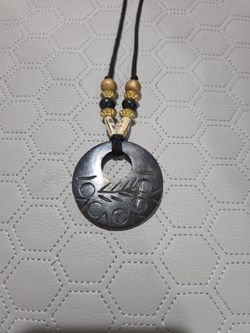 BLACK CORD NECKLACE WITH ROUND CARVED PENDANT