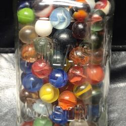 Antique metal top mason jar full of glass marbles