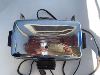 vintage General Electric waffle maker featuring a chrome exterior and dark bakelite handles