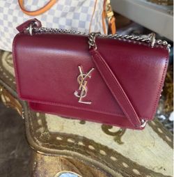 Burgundy leather Saint Laurent Sunset bag with silver YSL monogram hardware and chain strap. Flap closure with clean exterior leather.