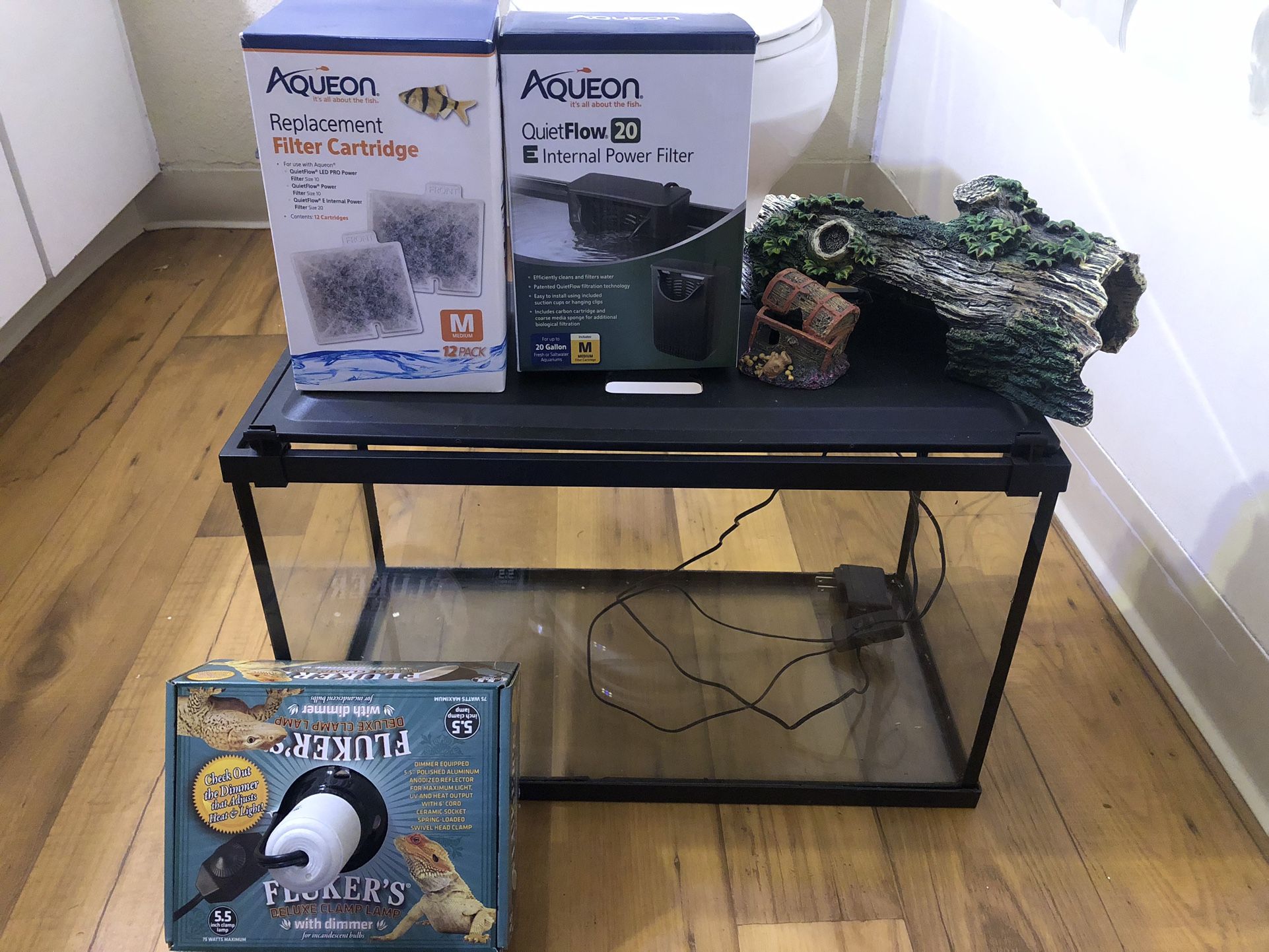 Fish Tank, Power Filter, Deluxe Clamp Lamp, Filter Cartridge 12 Pack and some Items for The Inside Of The Tank. 