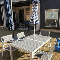 Outdoor Seating Area With Four Chairs, Cooshins, Umbrella, And table 