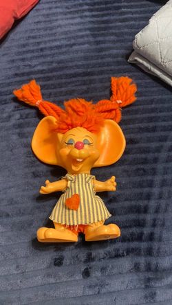 This character is a vintage 1970 Topo Gigio-style "Hillbilly Country Girl" mouse coin bank manufactured by Roy Des of Florida.