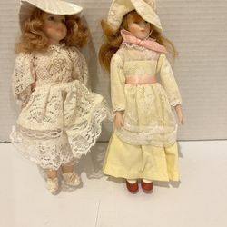 Two porcelain 8” dolls with nice outfits and hats.  The one with the yellow dress is made by Russ. 