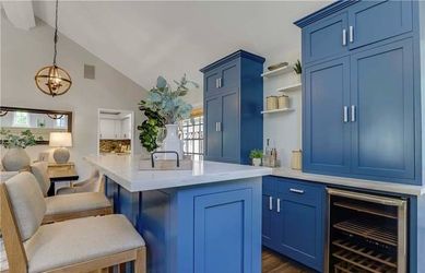 Custom Navy Blue Bar Cabinetry with Quartz Countertops, Matching Island & Two Beverage Refrigerators