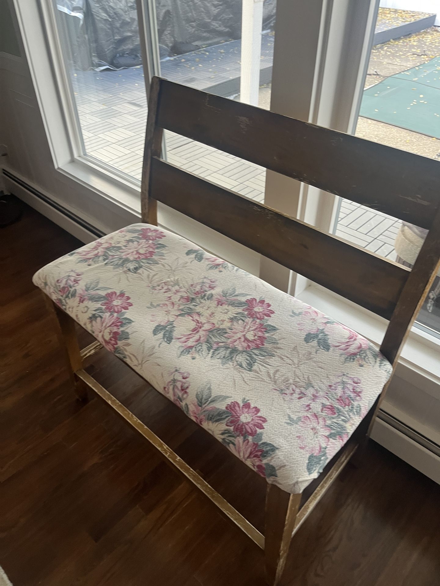 Wooden Bench. Distressed Brown Cushion Seats Two. Floral Print On Cushion.