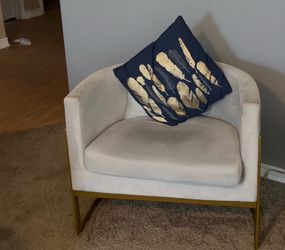 Two gray low back and brass chairs