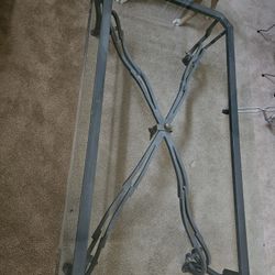 Beveled glass top coffee table and matching sofa table with an ornate metal base.