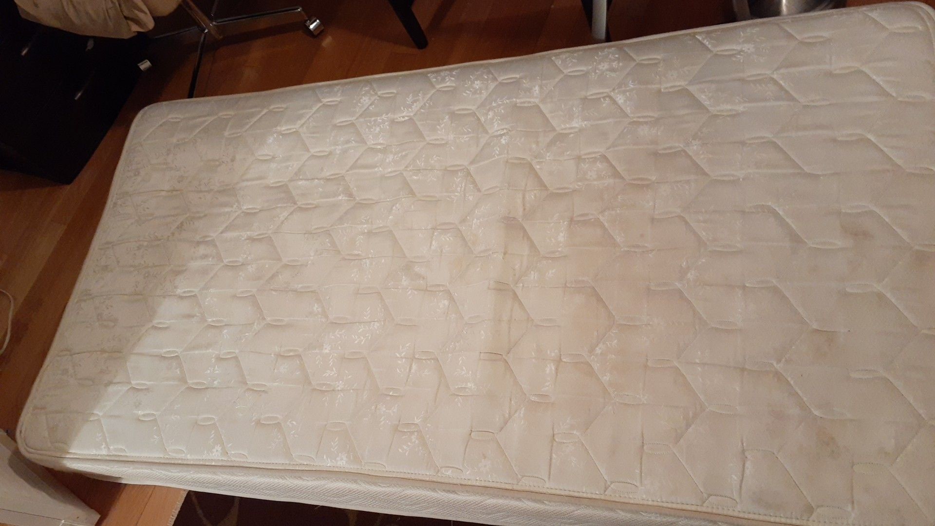 Bed with mattress and metal wheels