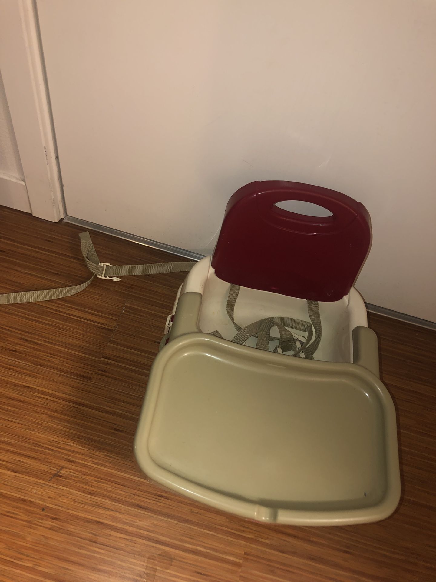 High chair for small child. Straps to a regular chair for safety. Detachable tray