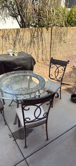 Glass outdoor table with four matching chairs glass top