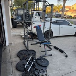 Bench press/squat rack with pulley systems and 7ft bar plus 230lbs of Olympic weights and adjustable dumbbells