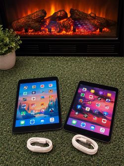 Two Apple iPads mini with Charging Cables
