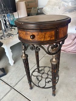 Beautiful vintage-style accent table with a unique antique look. Features a dark wood finish, decorative wood panels, elegant carved details, and orna