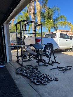 Pro gear bench press/squat rack with pulley system plus 253lbs of Olympic weights and 7ft 45lbs bar and weight tree