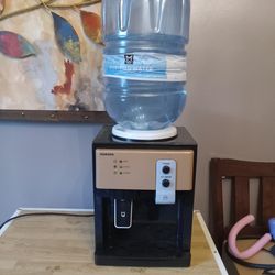 Countertop water dispenser has hot and cold water works great cash only