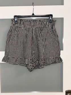 Vanilla Star black and white gingham shorts with a high-waisted, gathered elastic waistband and a classic ruffled hem. M
