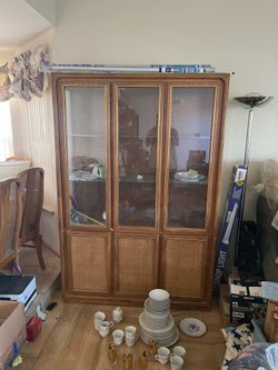 This is a vintage Modern china cabinet with a wood frame and cane paneling on the lower