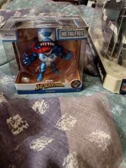 Miniature football helmets, and miniature metal Spyder man figurines.