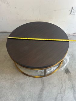 Coffee Table features a dark wood top contrasted with a gold metal