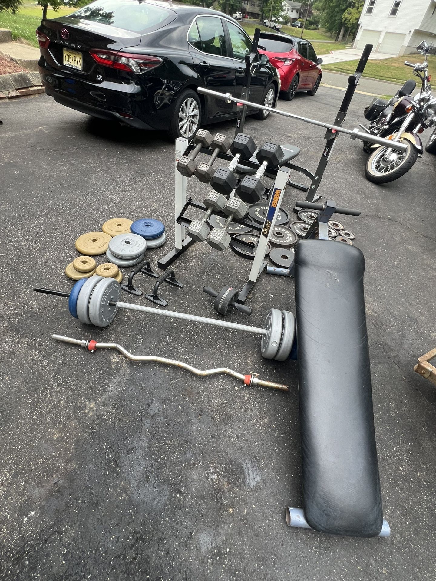 Home gym with decline, benchpress, dumbbells rack, barbell, curl bar, and weight plates
