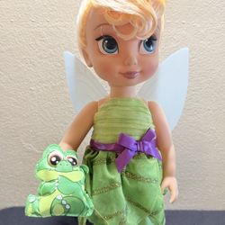 Tinker Bell is outfitted in a green satin dress with petal skirt overlay Sateen bodice with pleated organza overlay Contrast satin ribbon with bow at 