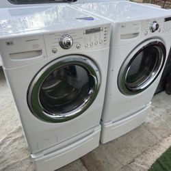 LG washer and electric dryer on pedestals 