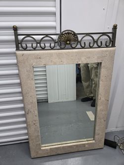 Stone-look mirror with metal scrollwork 