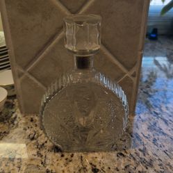 vintage 1960's Anchor Hocking clear glass decanter features a distinct fan-shaped pattern on the sides with starburst or daisy and button designs on t
