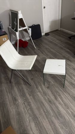 White Leather Chair With Metal Legs  And White Table With Glass  Leg Support 