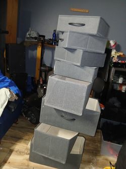 organizadores de tela o cajas de almacenamiento plegables, que parecen ser de color negro por fuera y de un tono más claro (crema o beige) por dentro.