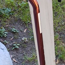 LIKE NEW COPPER COLOR CANE WITH BLACK HANDLE AND WRIST BAND
