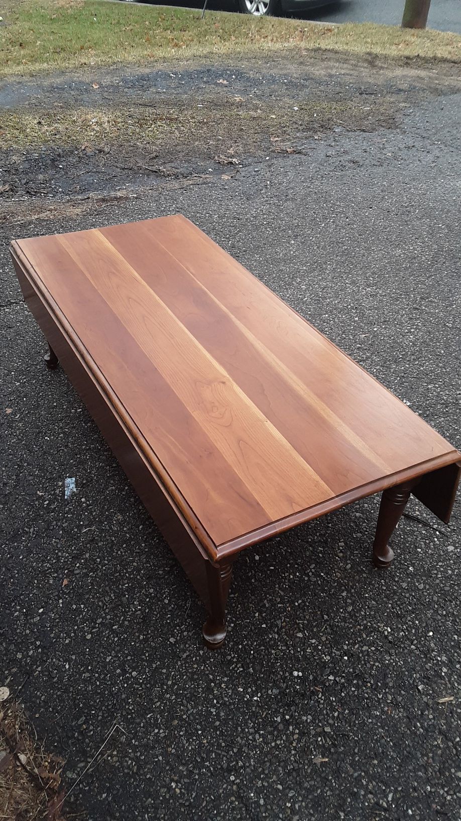 Solid cherry drop leaf coffee table with Queen Anne legs in new cond.