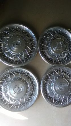 15 inch Cadillac hub caps, one missing center emblem.