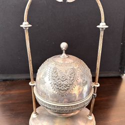 An antique American Aesthetic Movement style silver plate butter dish by the Meriden Britannia Company. The butter dish features a suspended spherical