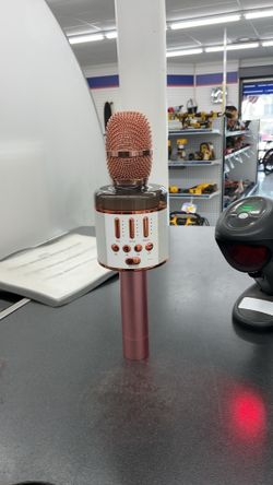 portable 3-in-1 karaoke microphone featuring a rose gold finish and a built-in speaker.