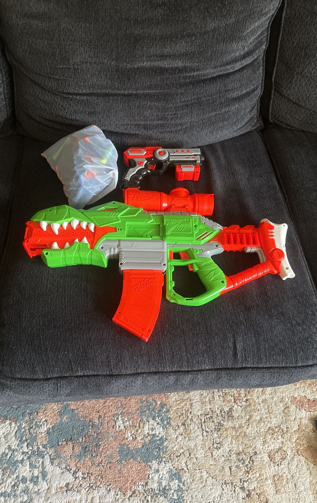 A Nerf gun with a pistol with a bag full of ammo