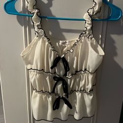 Cream top with ruffles and black bows