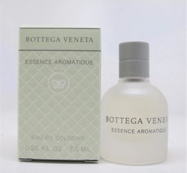 A small boxed bottle of Bottega Veneta Pour Homme Essence Aromatique cologne displayed on a fur-like surface. The product and packaging indicate a fra